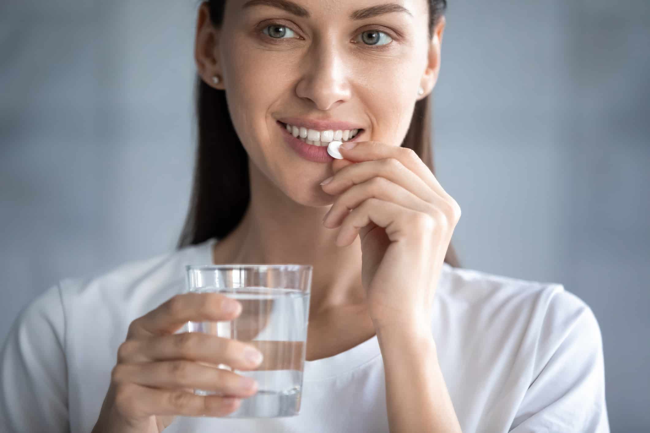 Woman taking a probiotic understanding the pros and cons of taking probiotics daily