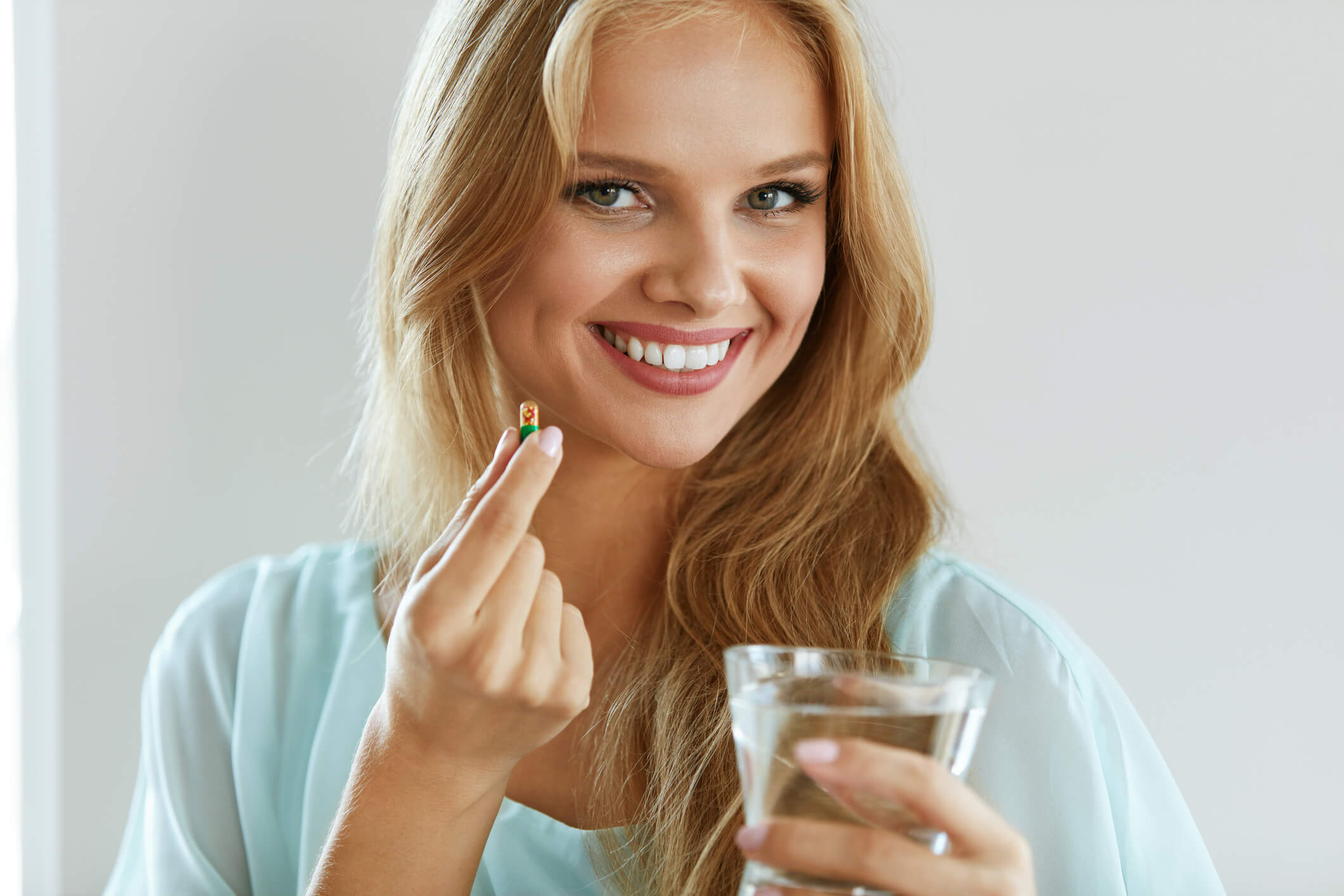 Woman taking a probiotic supplement as part of her daily routine