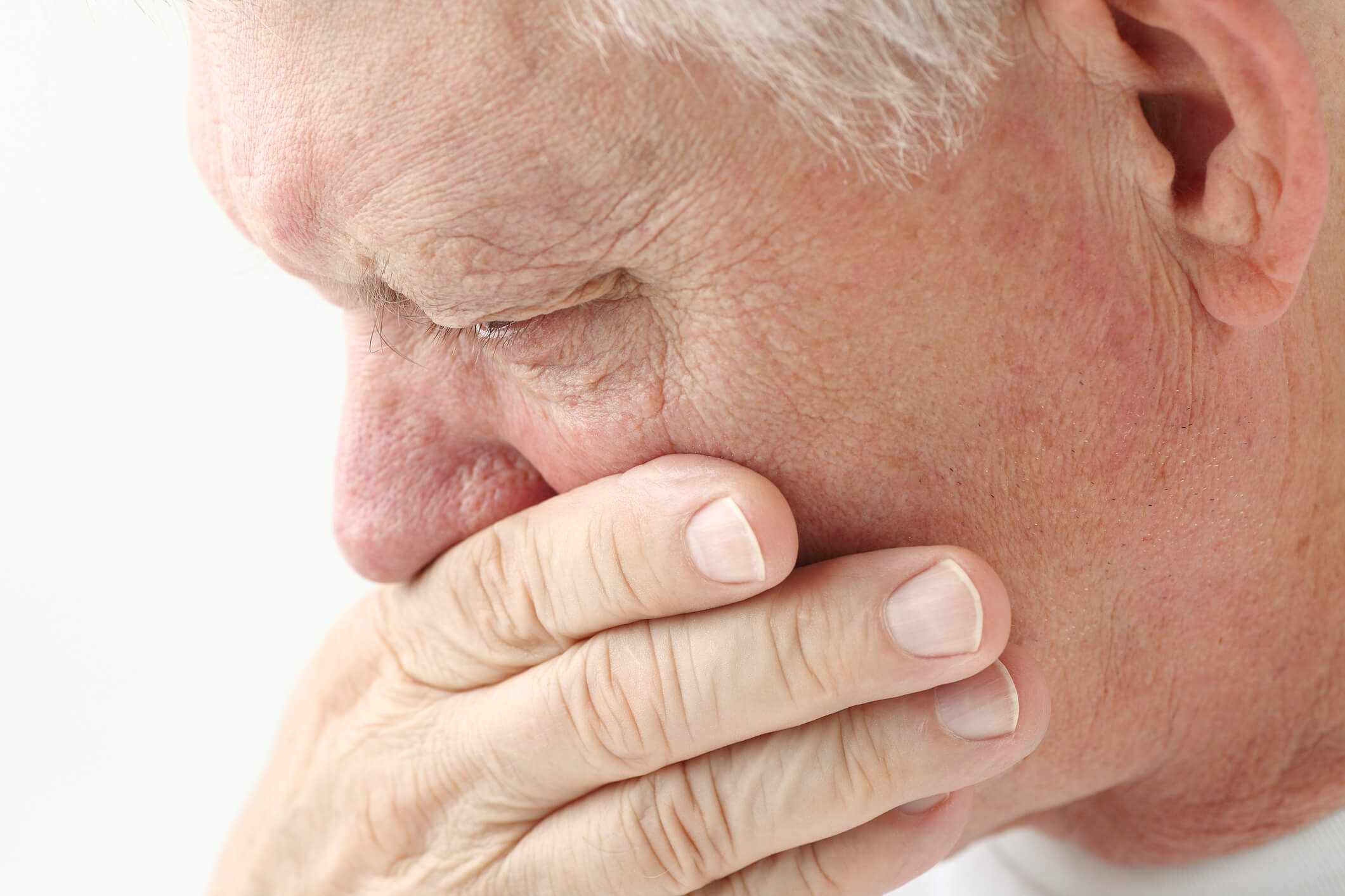 Nauseated mature man holds hand up to mouth