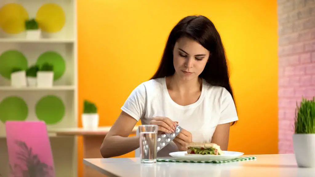 Woman deciding to take her probiotics with food