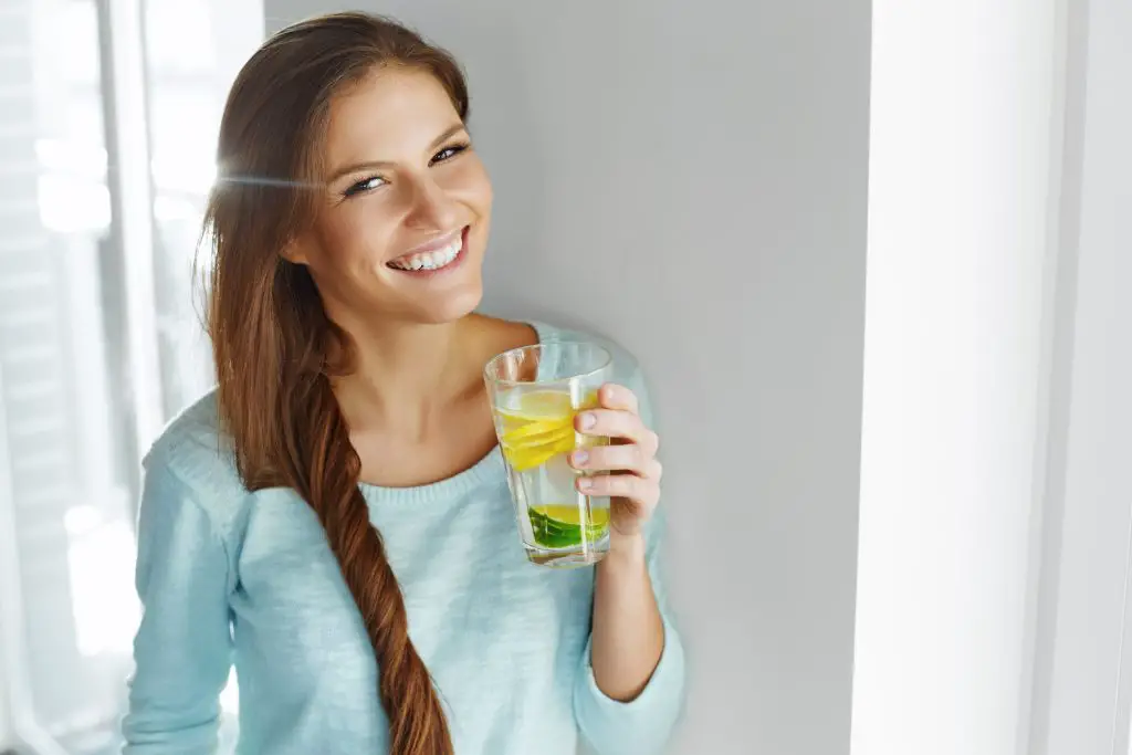 Woman drinking lots of fluid to hydrate as part of her detox from probiotics - how to flush out probiotics from your system